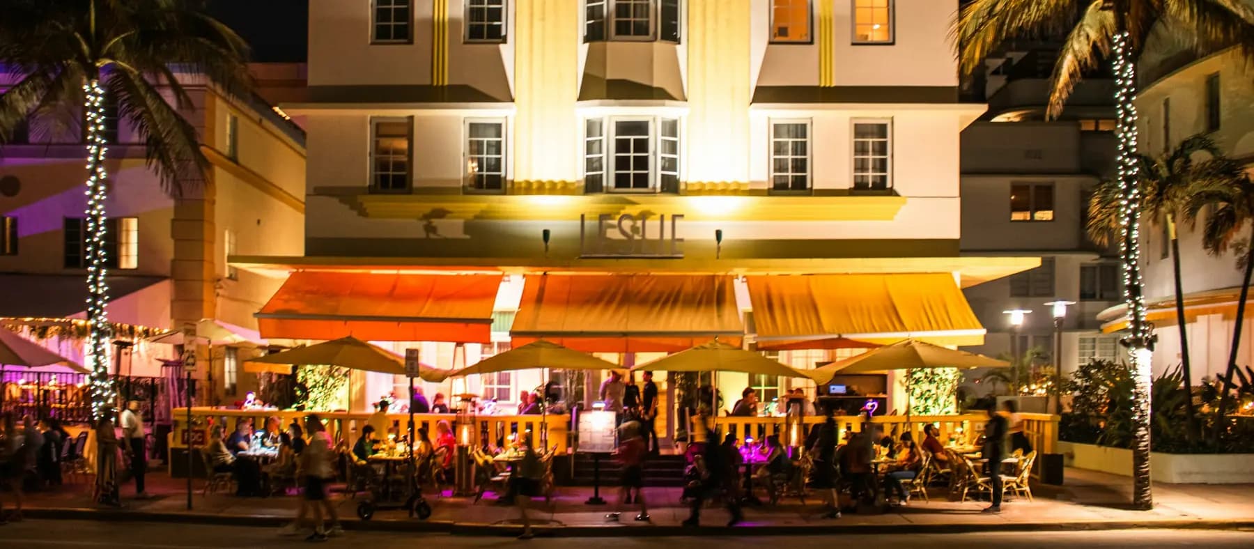 A hotel terrace busy with guests on a warm evening during peak season
